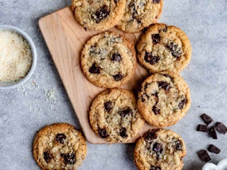 5 chocolate chip cookies on a cutting board with a brown sugar pot