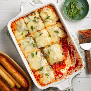 Vegetable lasagna with white sauce in a square bowl garnished with some greens
